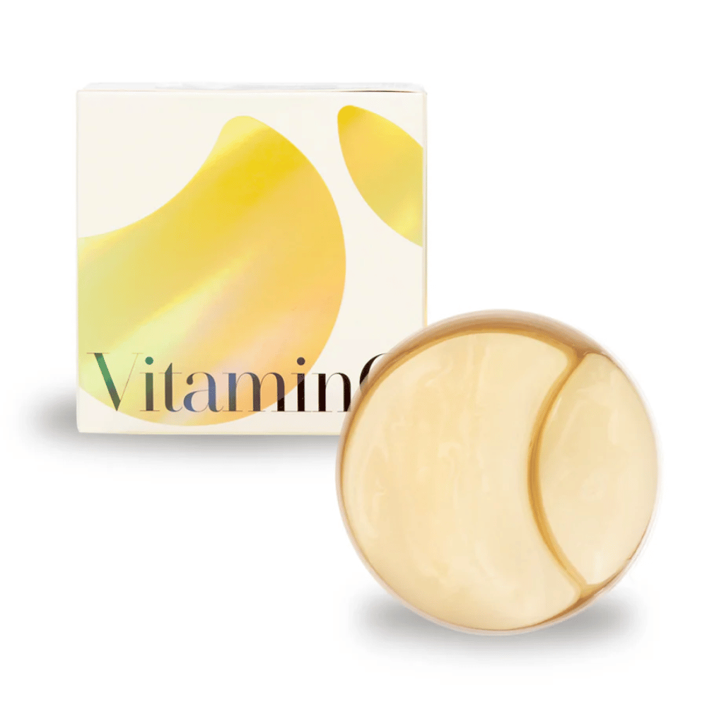 K-Secret Extra Illuminating Eye Gel Patches z vitaminom C v zlato bleščečem hidrogelu, posoda in embalaža v ozadju.