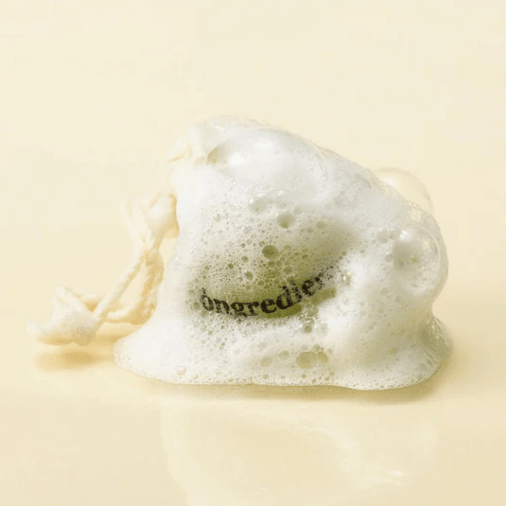 Óngredients Jeju Green Tea Cleansing Ball v mrežasti vrečki, prekriti z mehko peno – naravno korejsko milo za obraz.