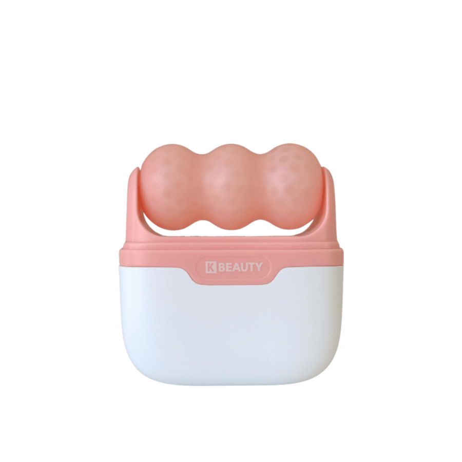 Slika prikazuje K-Beauty Ice Roller z belim in roza ročajem. Izdelek ima tri zaobljene, pikčaste valjčke v roza barvi na vrhu, zasnovane za hlajenje in masažo obraza. Ozadje je popolnoma belo.