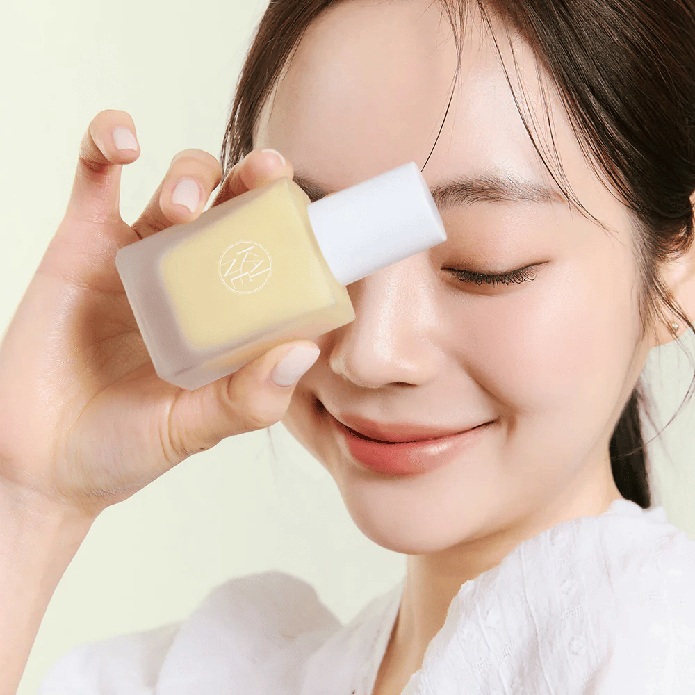 Ženska drži stekleničko KAINE Vita Drop Serum 30ml.