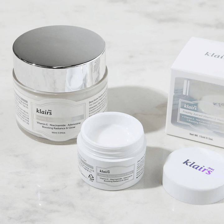 Zbirka izdelkov za nego kože Klairs na marmorni klopi: zaprta posoda, odprta posoda s kremo in škatla z besedilom.