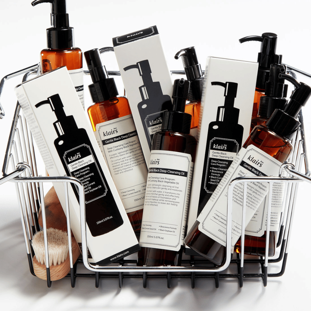 Mini voziček, napolnjen z izdelki za nego kože Klairs, vključno z Gentle Black Deep Cleansing Oil v prozornih steklenicah s črnimi črpalkami in ustreznimi embalažami.