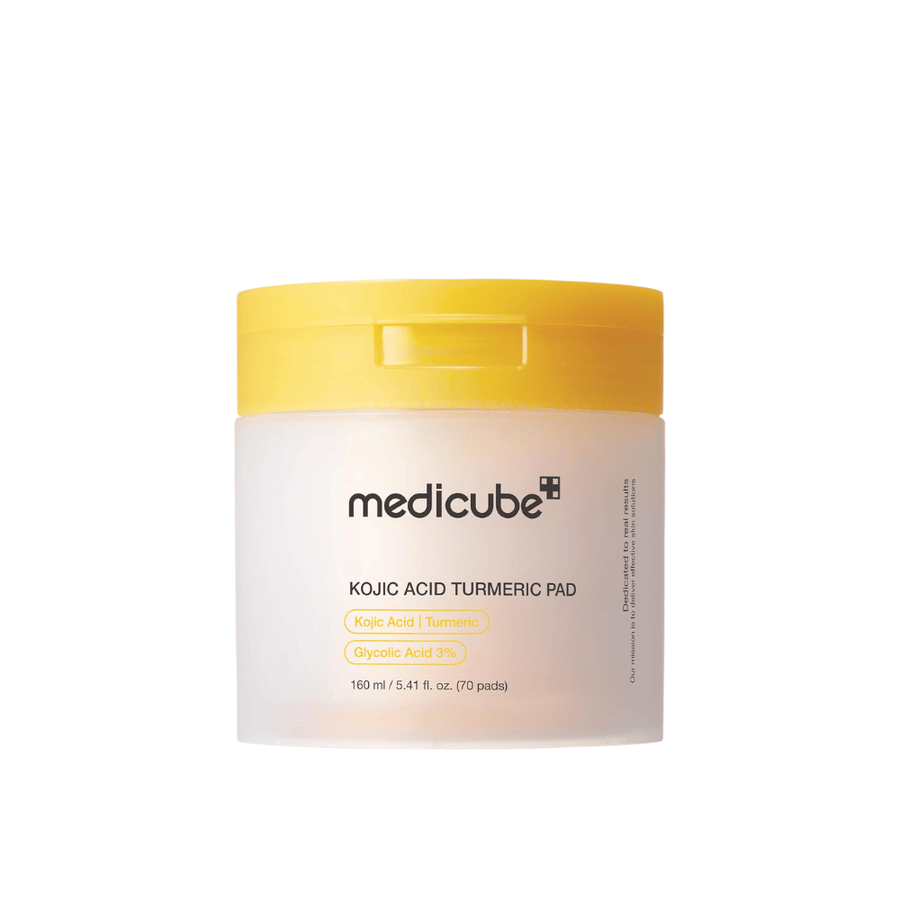 Izrezana produktna slika Medicube Kojic Acid Turmeric Pad v rumeni embalaži z eksfoliacijskimi blazinicami, ki vsebujejo kojično kislino, kurkumo in glikolno kislino za bolj enakomeren ten kože in sijaj.