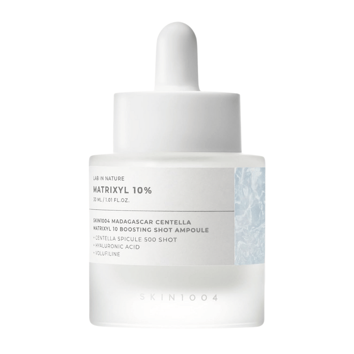 Bližnji posnetek SKIN1004 Madagascar Centella Matrixyl 10 Boosting Shot Ampoule prikazuje pipeto in etiketo – visokokoncentriran peptidni serum za elastičnost kože in vlaženje.
