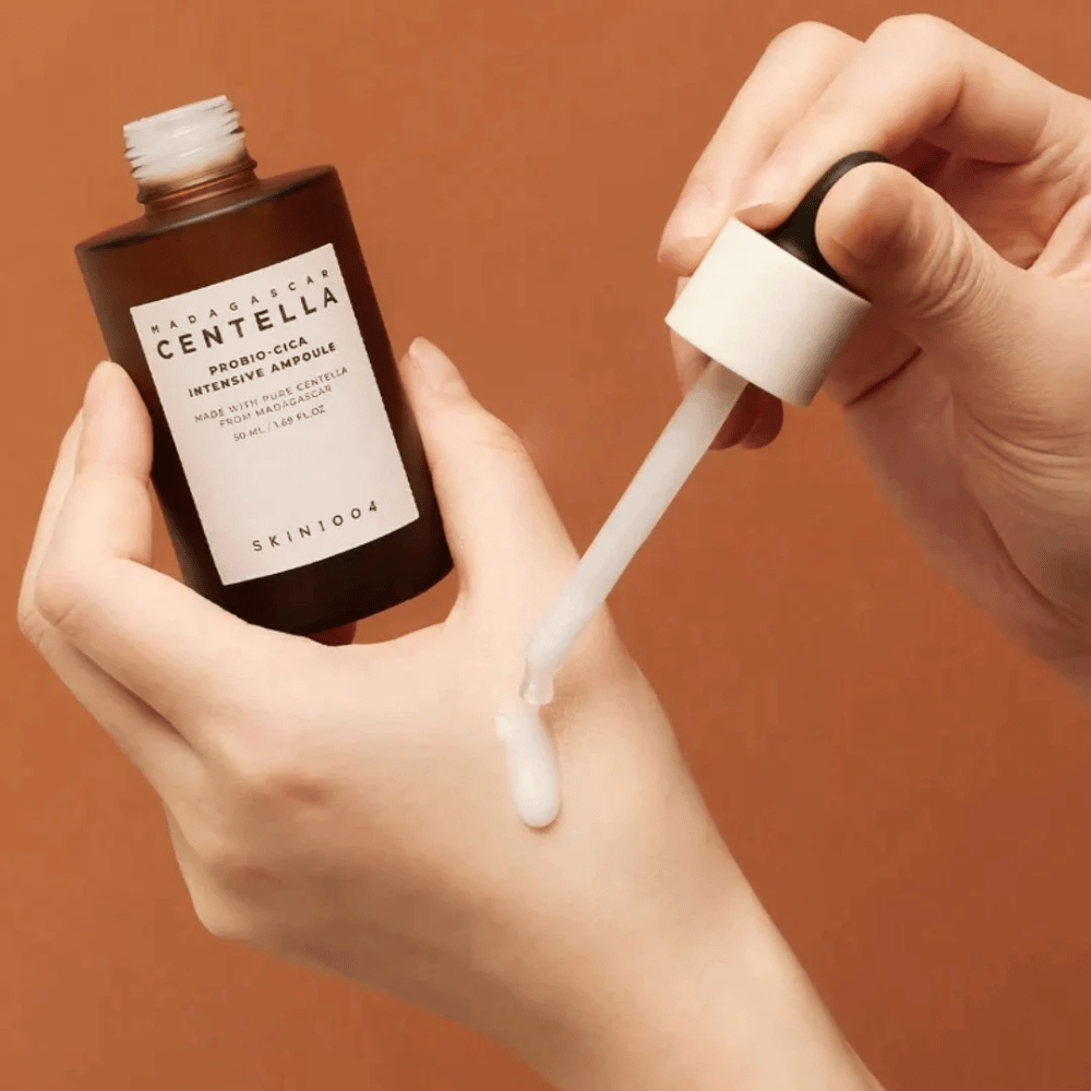 Roke, ki uporabljajo kapalko za doziranje "Madagascar Centella Probio-Cica Intensive Ampoule" od SKIN1004.
