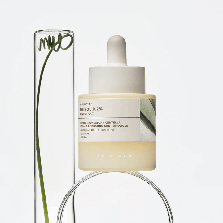 SKIN1004 Madagascar Centella Retinol 0.2 Boosting Shot Ampoule v življenjskem slogu z botaničnimi elementi – obrazni serum, ki podpira obnovo kože in krepi kožno pregrado.