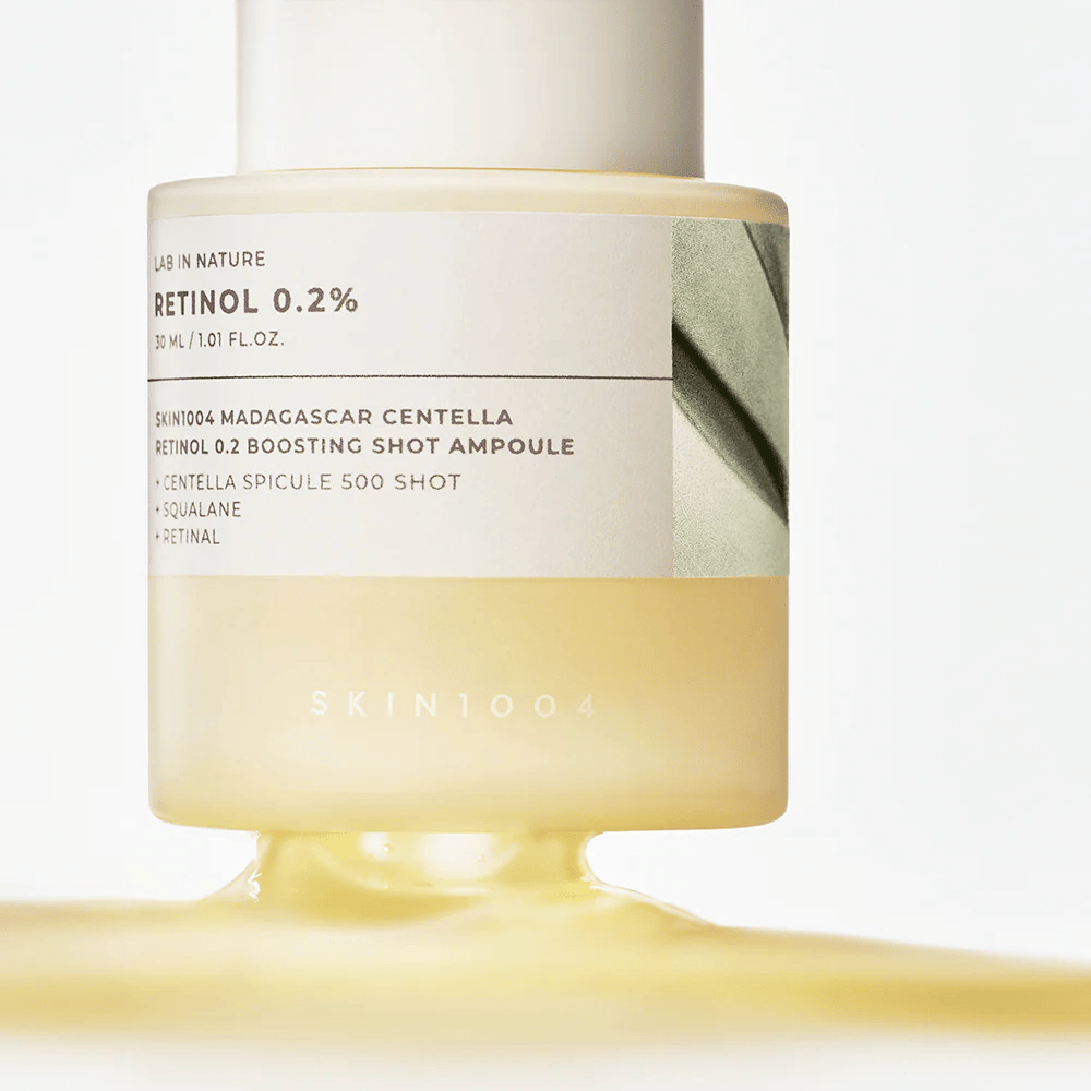 Povečana slika SKIN1004 Madagascar Centella Retinol 0.2 Boosting Shot Ampoule, ki prikazuje svetlo rumeno, svilnato teksturo retinol seruma za nočno obnovo kože.