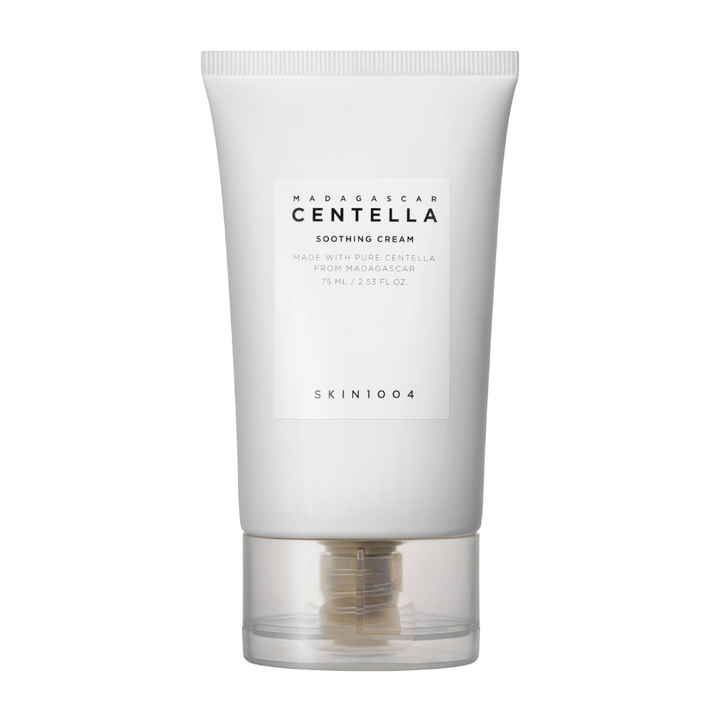 Bela tuba Madagascar Centella Soothing Cream od SKIN1004 s prozornim pokrovčkom. Besedilo na tubi opisuje izdelek kot pomirjujoč in narejen s čisto Centello iz Madagaskarja. Tuba vsebuje 75 ml / 2.53 fl. oz.