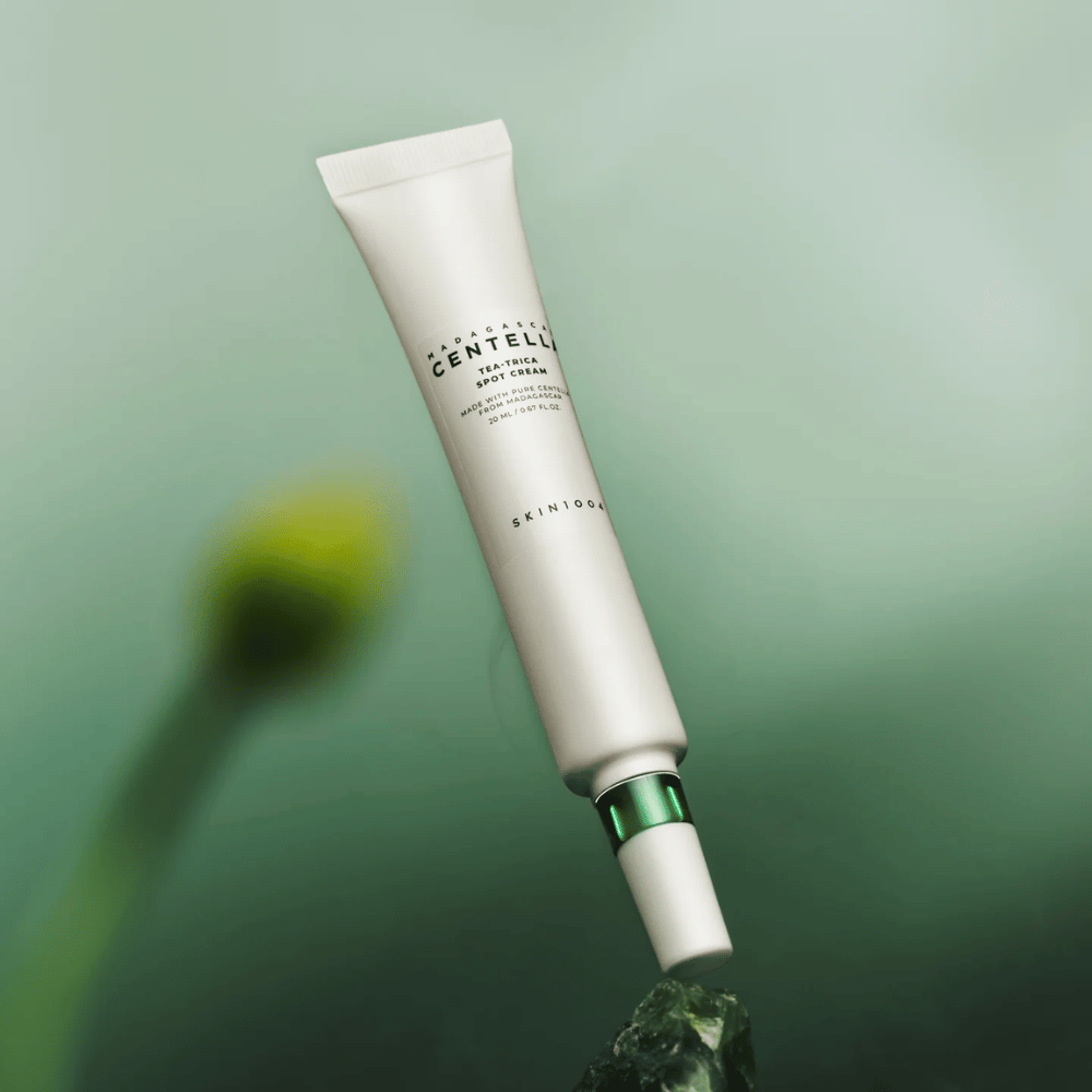 SKIN1004 Madagascar Centella Tea-Trica Spot Cream lebdeč na zeleni podlagi – učinkovita točkovna treatment za kožo, nagnjeno k aknam, s centello iz Madagaskarja.