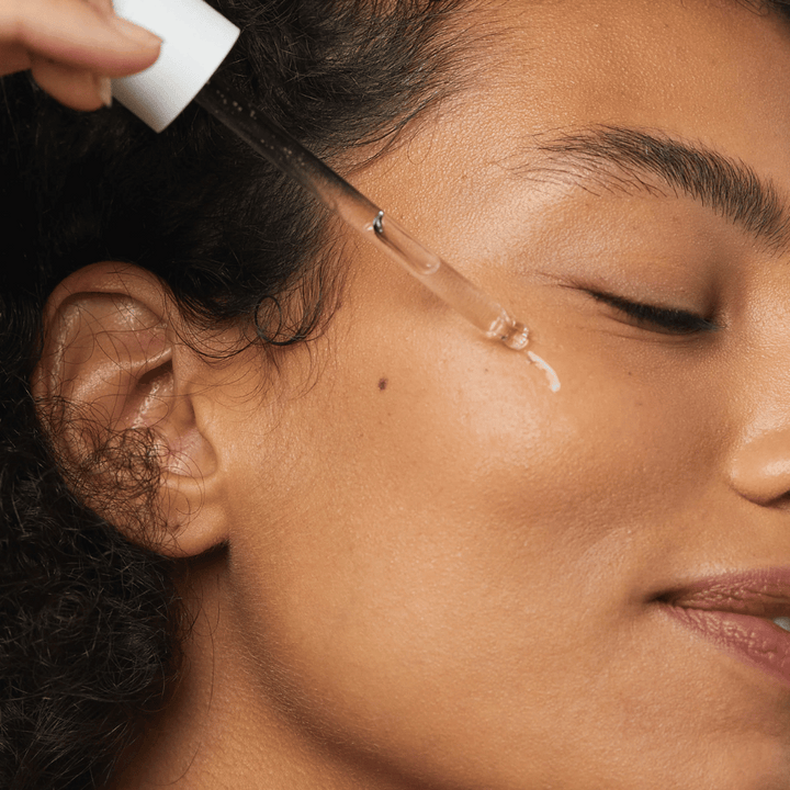 Ženska nanaša Skin1004 Madagascar Centella Hyalu-Cica First Ampoule na lice s pipeto.