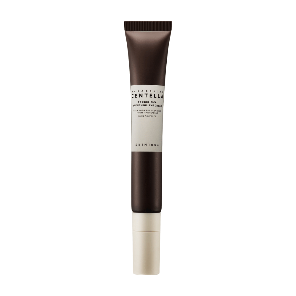 Tuba "Madagascar Centella Probio-Cica Bakuchiol Eye Cream" od SKIN1004. Izdelek je zasnovan za področje okoli oči in vsebuje sestavine, kot sta centella iz Madagaskarja in bakuchiol, znana po svojih negovalnih in vlažilnih lastnostih. Tuba je elegantna s temno rjavo barvo, ki prehaja v belo.
