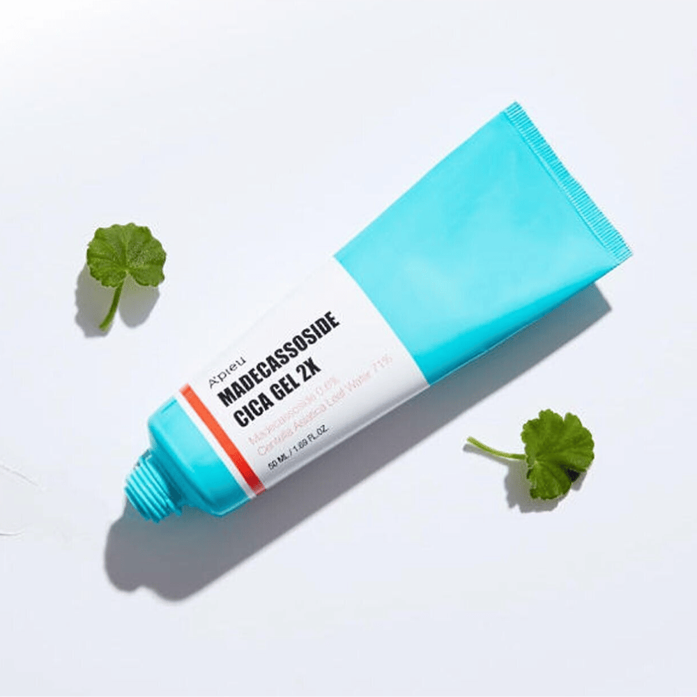 A’pieu Madecassoside Cica Gel 2X v modri tubi z belo etiketo, obdano s tremi zelenimi listi centella asiatica na belem ozadju.