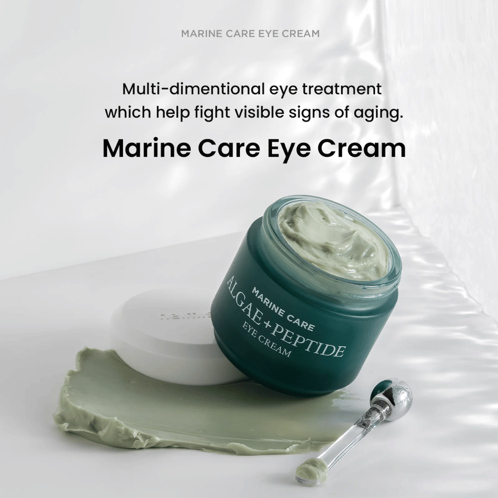Heimish Marine Care Algae + Peptide Eye Cream v odprti posodi z zelenkasto kremo. Krema je razporejena poleg posode, aplikator pa leži zraven. Izdelek se bori proti znakom staranja in zagotavlja intenzivno vlaženje.