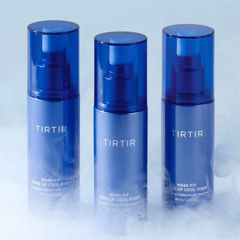 Tri modre razpršilne stekleničke z oznako "TIRTIR Mask Fit Make Up Cool Fixer". Vsaka steklenička vsebuje 80 ml (2,70 fl. oz.) in je zasnovana za osvežujoč občutek ter dolgotrajna ličila. Stekleničke stojijo na svetlem ozadju z meglico, da ustvarijo vzdušje svežine.