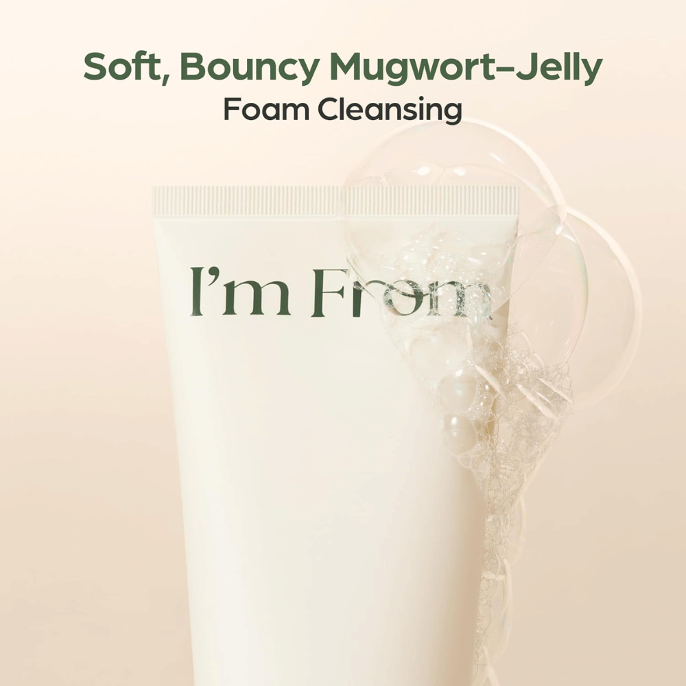 I'm From Mugwort Gel Cleanser z mehko želejasto teksturo, ki tvori čistilno peno. Bližnji posnetek bež tube s prozornimi mehurčki pene.