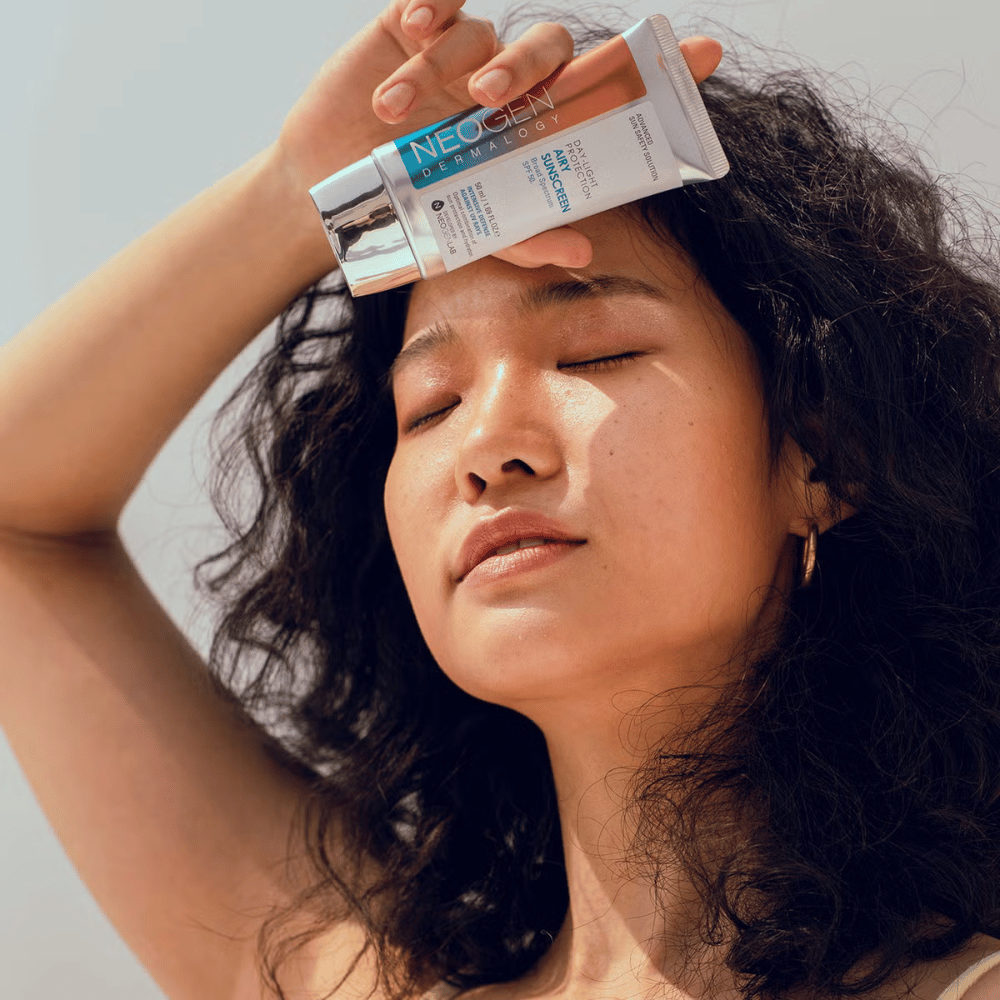Neogen Dermalogy Day-Light Protection Airy Sunscreen SPF50 50ml – lahka sončna krema s širokim spektrom UV-zaščite, prikazana v uporabi na sončni svetlobi.