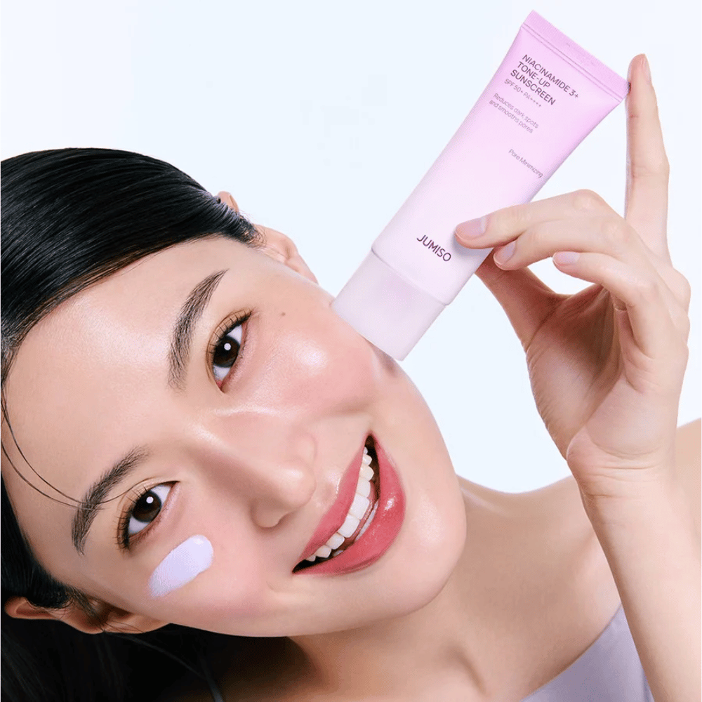 Model nanaša JUMISO Niacinamide 3+ Tone-Up Sunscreen SPF50+ PA++++ za UV-zaščito, bolj enakomeren ten kože in naraven sijaj.