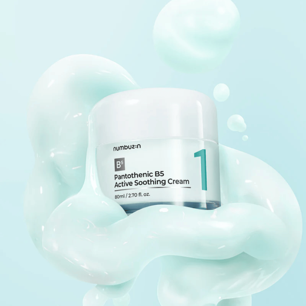 Numbuzin No.1 Pantothenic B5 Active Soothing Cream 80 ml v svetlo zeleni posodi z belim pokrovom, obdana z mehkimi valovi svetlo zelene kremaste teksture na svetlo modrem ozadju.
