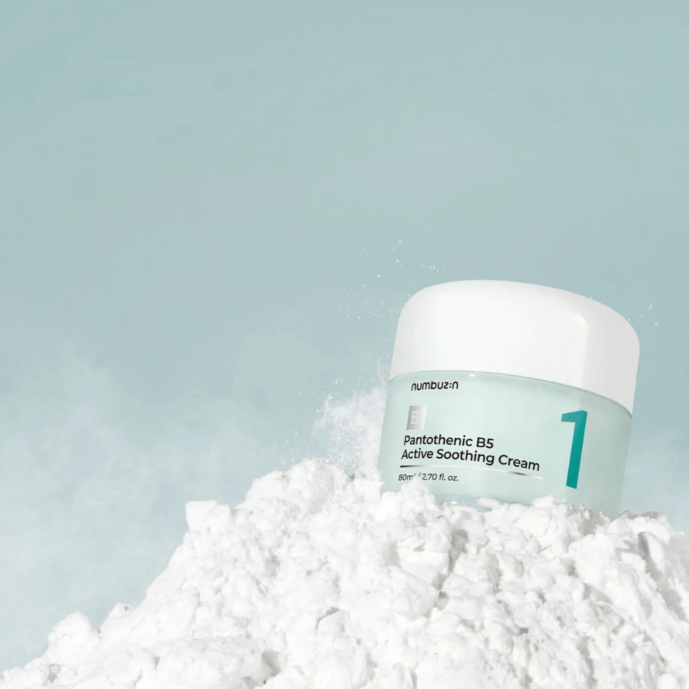 Numbuzin No.1 Pantothenic B5 Active Soothing Cream 80 ml v svetlo zeleni posodi z belim pokrovom, postavljena na kup belega prahu na svetlem ozadju.