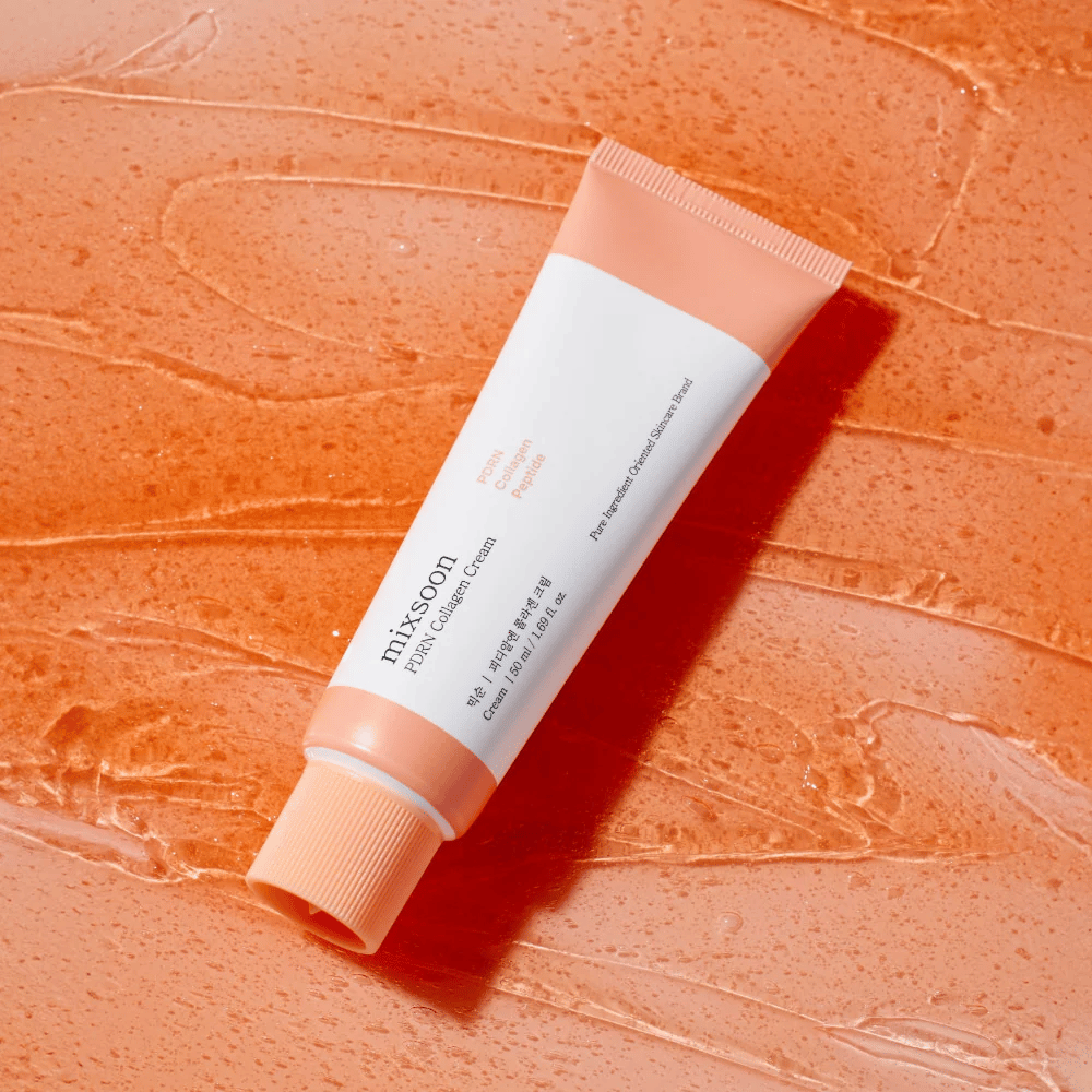 Mixsoon PDRN Collagen Cream leži na sijočem oranžnem ozadju. Hranilna krema za obraz s PDRN, kolagenom in peptidi za čvrstejšo kožo.