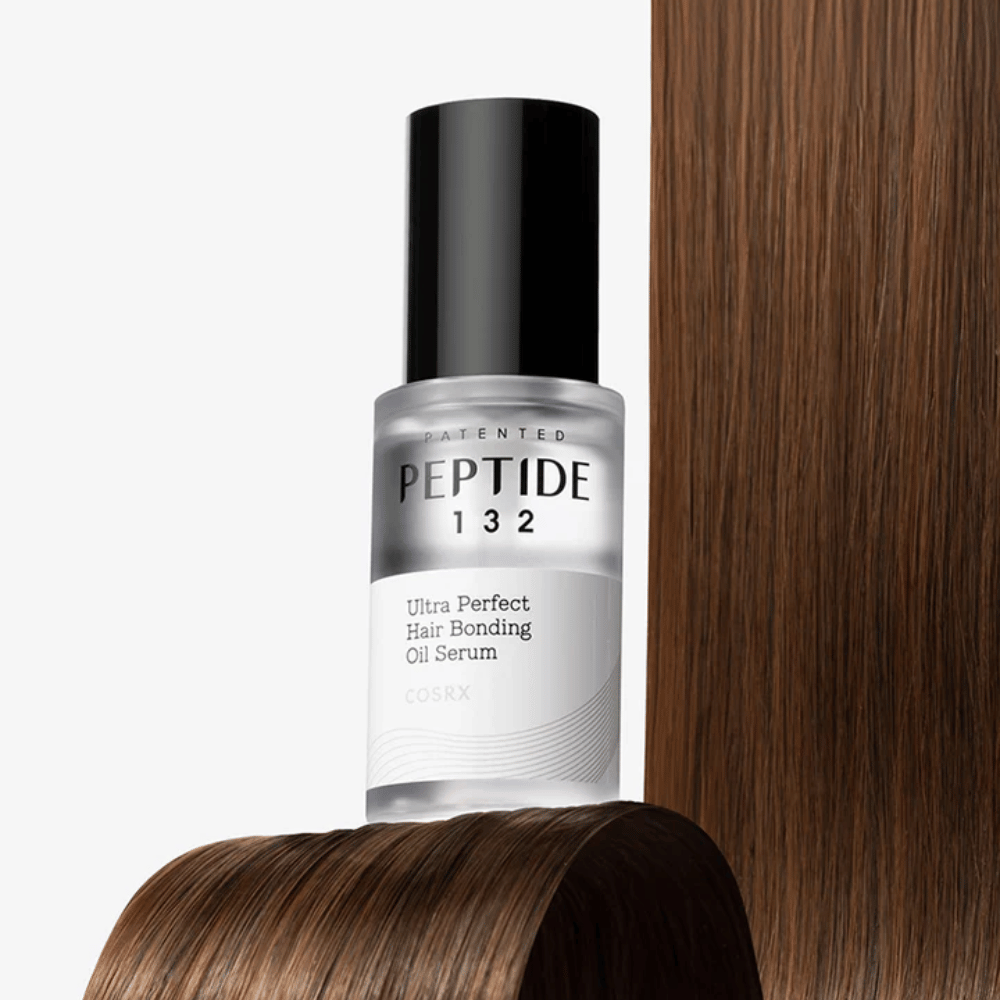 COSRX Peptide 132 Ultra Perfect Hair Bonding Oil Serum postavljen proti sijočim lasem – daje moč, mehkobo in sijaj.