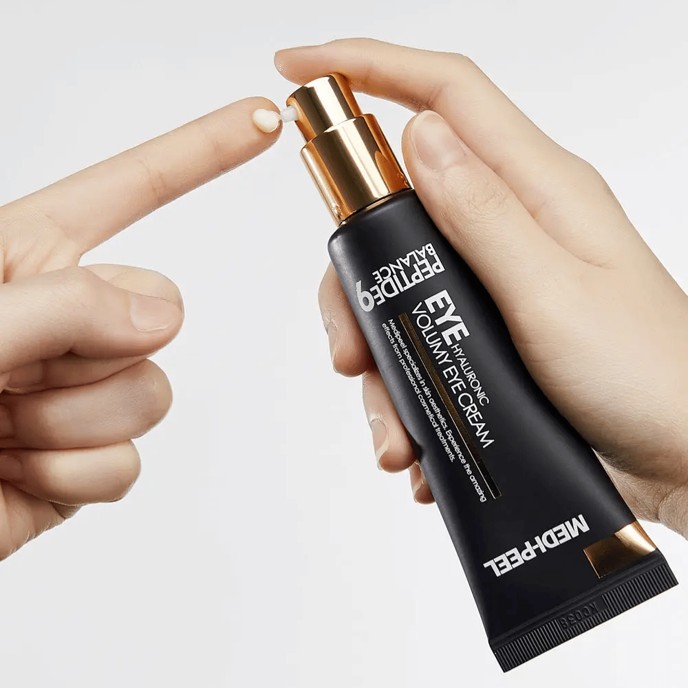 Nanašanje MEDI-PEEL Peptide 9 Hyaluronic Volumy Eye Cream na konico prsta – vlažilna krema za oči s peptidnim kompleksom, ki pomaga zmanjšati drobne linije in daje napeto kožo.