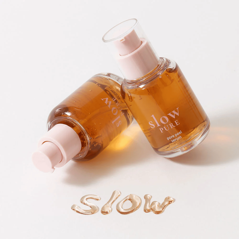 Dve steklenički Slow Pure Pore Peel Serum s črpalko, besedilo napisano v serumu na površini: "Slow".