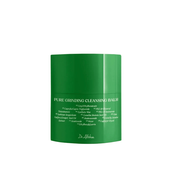 Slika prikazuje zeleno posodico z "Pure Grinding Cleansing Balm" od Dr. Althea. Embalaža je preprosta in elegantna z belim besedilom, ki navaja ključne sestavine, kot so olje grozdnih pečk, izvleček centella asiatica in olje kamelijinih semen. Dizajn prenaša občutek naravne in učinkovite nege kože.