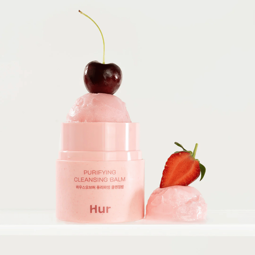 Odprt Kako Purifying Cleansing Balm s teksturo, podobno sorbetu, okrašen s češnjami in jagodami. Čistilni balzam, navdihnjen s sadjem, z mehčalnimi in čistilnimi lastnostmi.