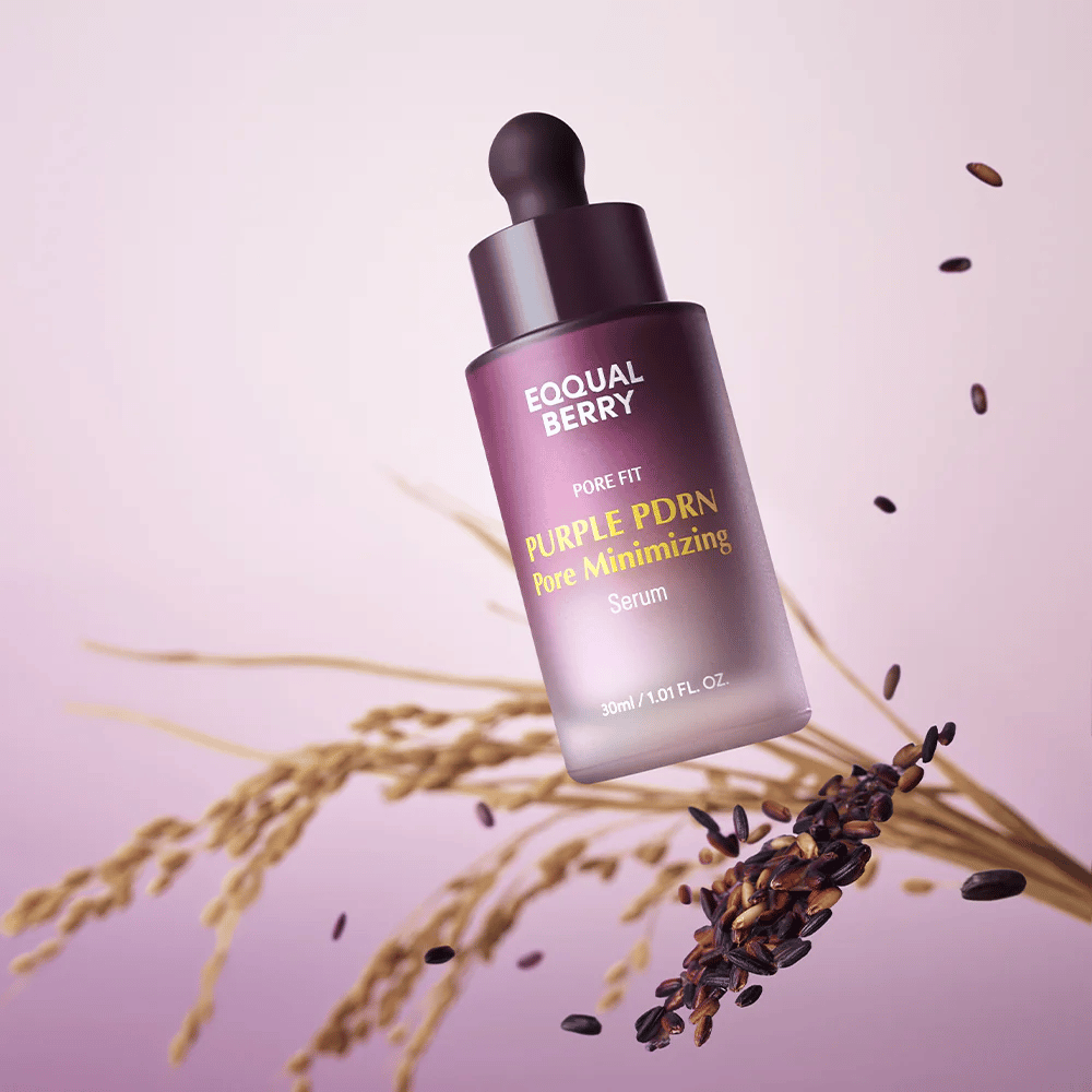 Steklenička z Equal Berry Purple PDRN Pore Minimizing Serum lebdi na vijoličnem ozadju, obdana s črnimi riževimi zrni in riževimi stebli.