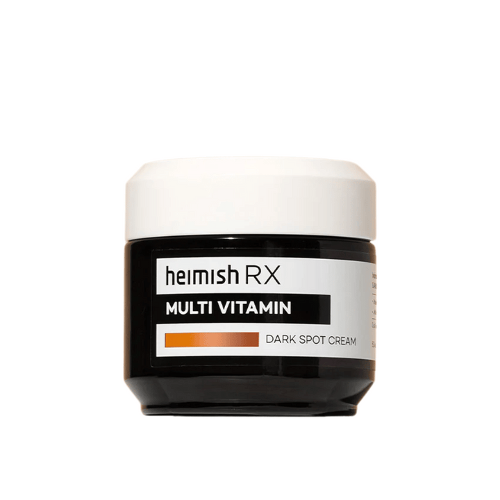 Heimish RX Multi Vitamin Dark Spot Cream v elegantni črni posodi z belim pokrovom. Obrazna krema, obogatena z multivitamini, zasnovana za zmanjšanje temnih madežev in izenačevanje tena kože.