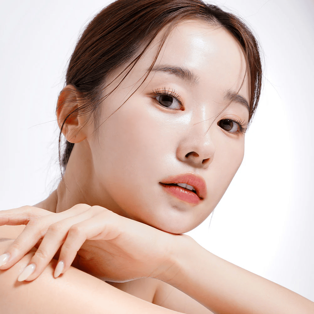 Povečana slika ženske s sijočo in navlaženo kožo. Njena naravna lepota je poudarjena z mehko osvetlitvijo, kar daje svež in zdrav videz.