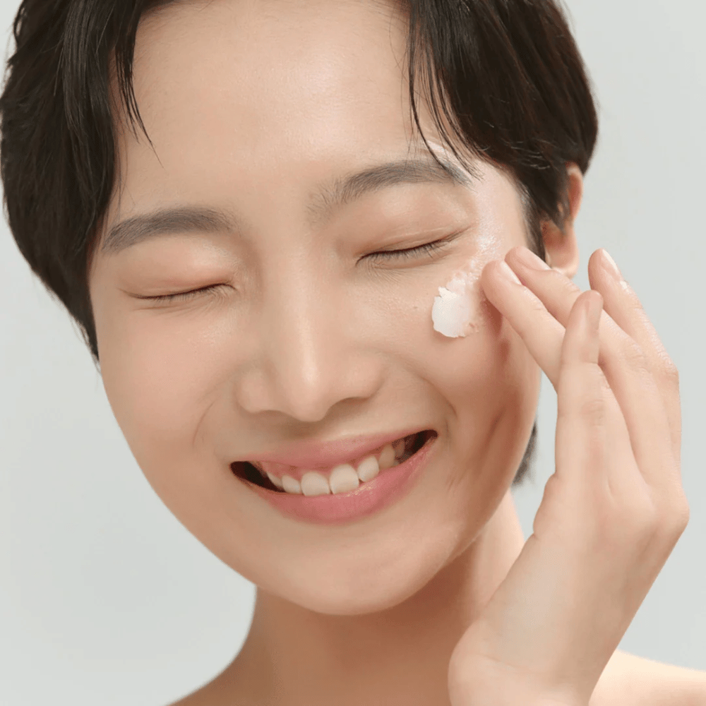 Model z sijočo kožo nanaša Beauty of Joseon Radiance Cleansing Balm – korejski čistilni balzam, ki odstrani ličila in nečistoče.