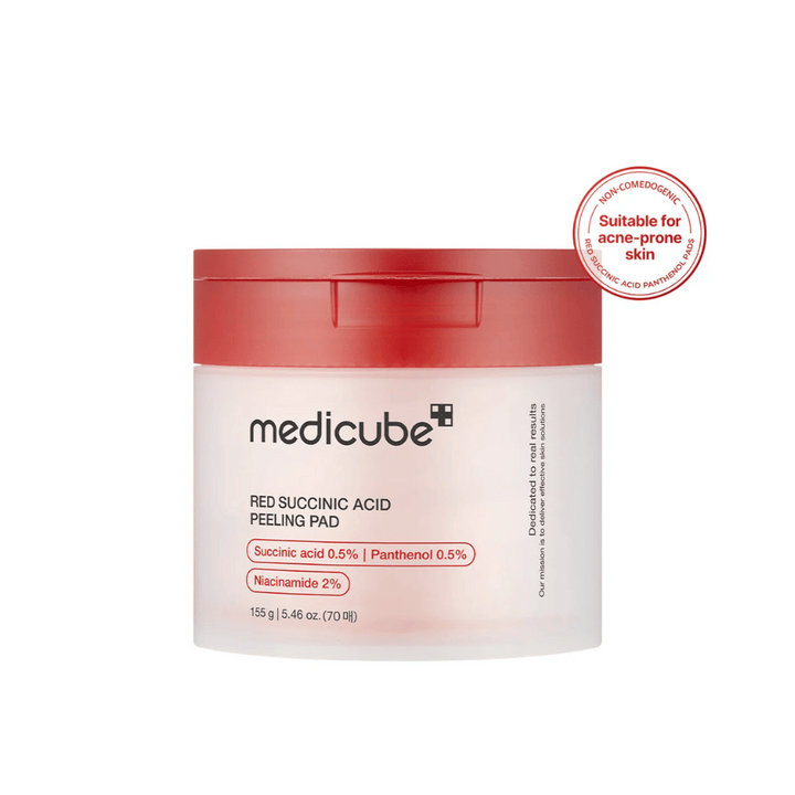 Medicube Red Succinic Acid Peeling Pad v beli posodi z rdečim pokrovom, zasnovana za kožo, nagnjeno k aknam. Vsebuje sukcinsko kislino, pantenol in niacinamid za izboljšanje strukture kože in nežno eksfoliacijo. Nekomedogena formula.