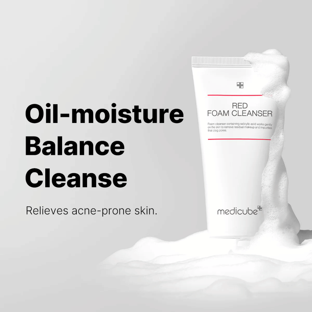 Tuba z Medicube Red Foam Cleanser stoji pokonci med penastim milom. Besedilo "Oil-moisture Balance Cleanse" se prikaže na levi strani, z opisom "Lajša kožo, nagnjeno k aknam" spodaj. Ozadje je svetlo sivo.