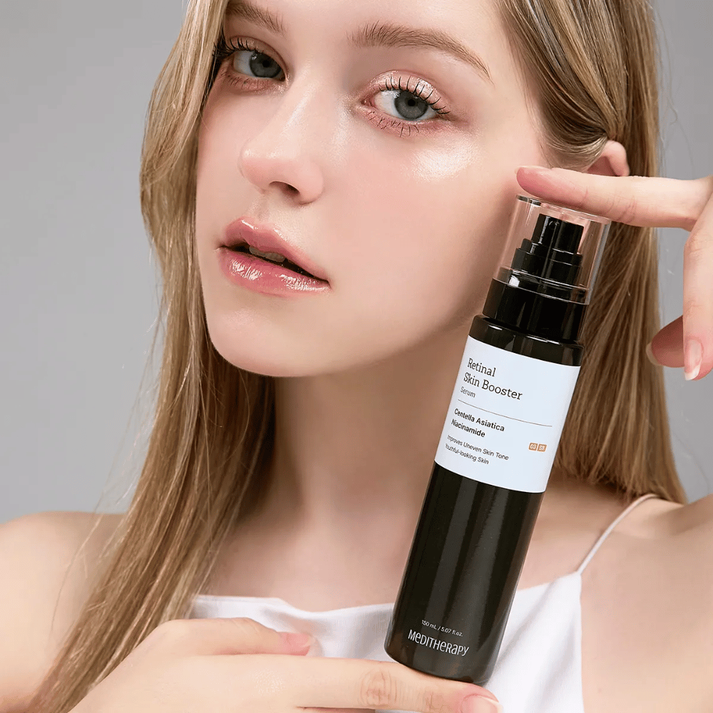 Oseba drži Meditherapy Retinal Skin Booster Serum. Koža izgleda enakomerna, navlažena in sijoča – rezultat retinala in niacinamida.