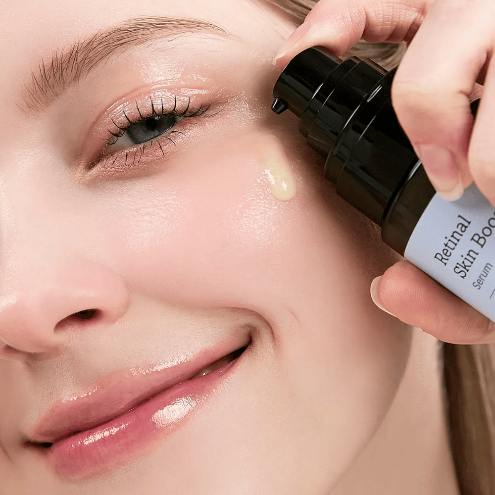 Oseba nanaša Meditherapy Retinal Skin Booster Serum blizu očesa. Serum ima lahko, rumeno barvo in koži daje sijaj in čvrstost.