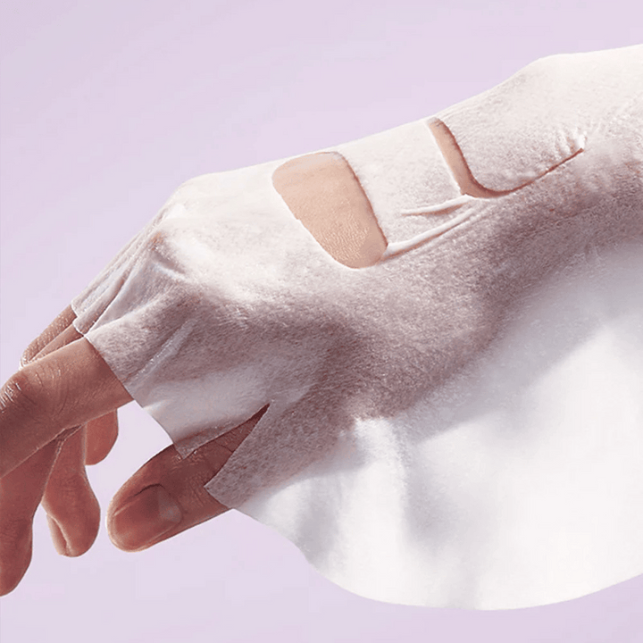 Slika prikazuje roko z "Retinol Intense Reactivating Mask" naneseno na kožo. To je lepotni izdelek za nego kože.