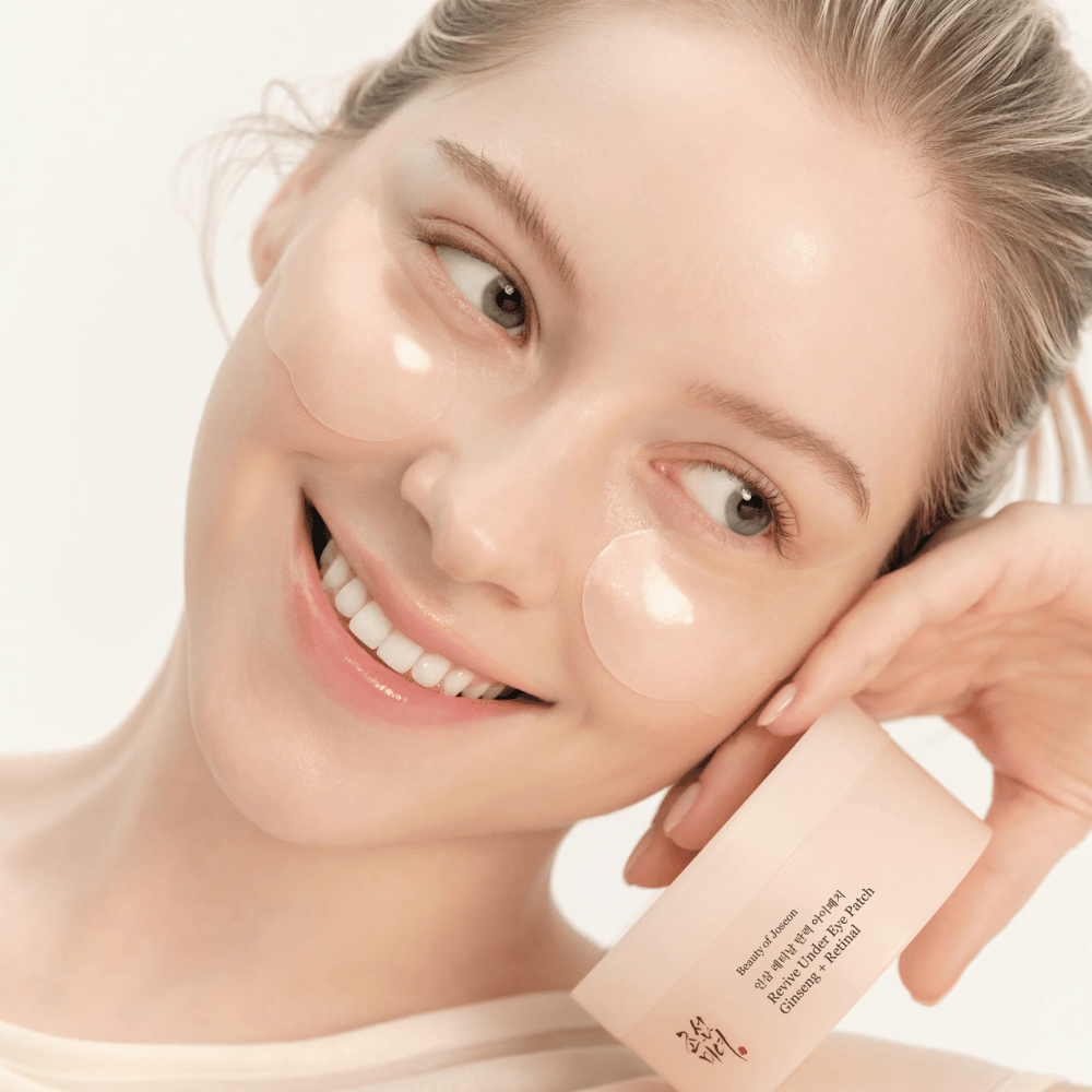Model z Beauty of Joseon obliži za oči in izdelkom v roki, obliži za oči z ginsengom in retinalom za bolj živahno in gladko področje okoli oči.
