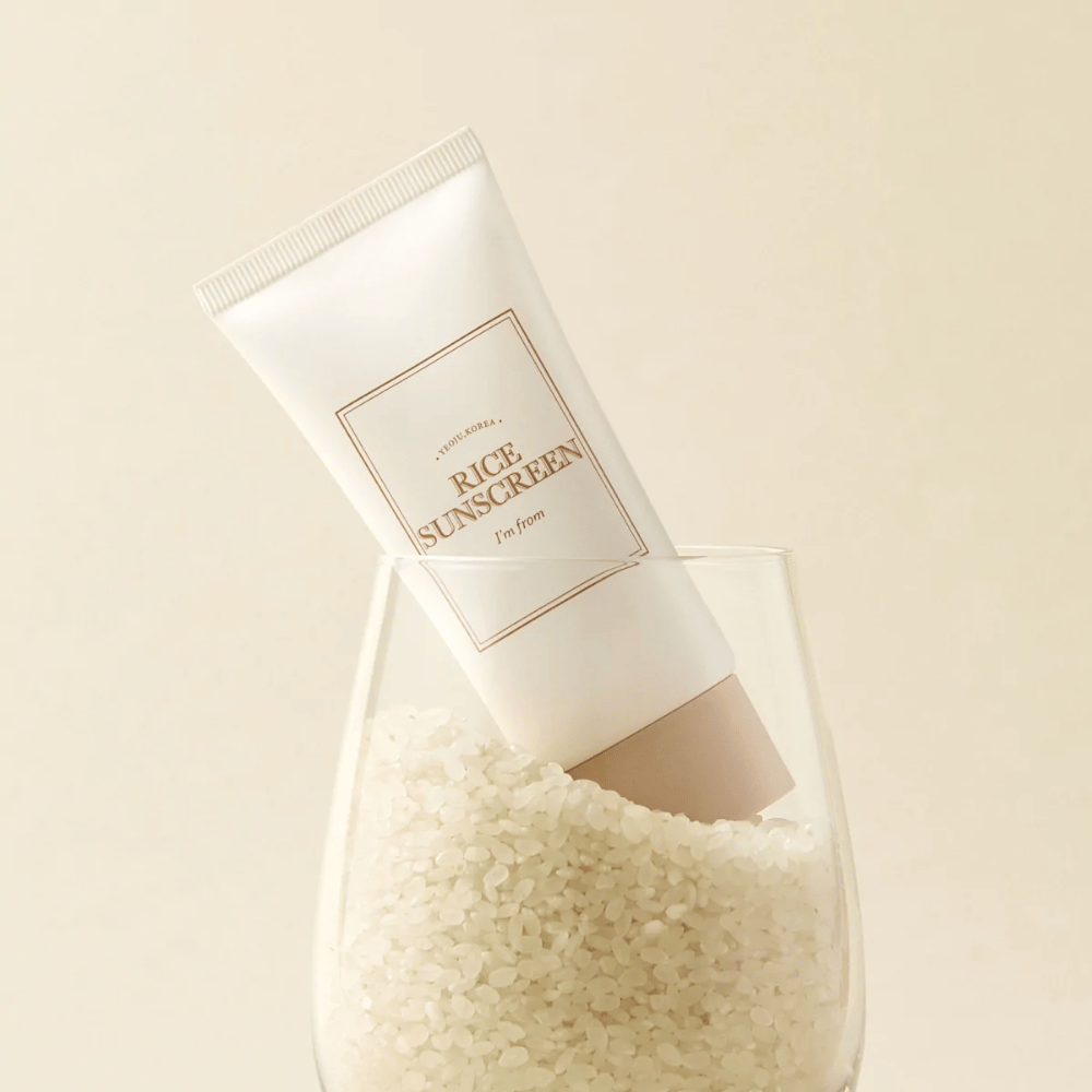 Tuba z "I'm from" Rice Sunscreen, SPF50+ PA++++, postavljena v kozarec z riževimi zrni.