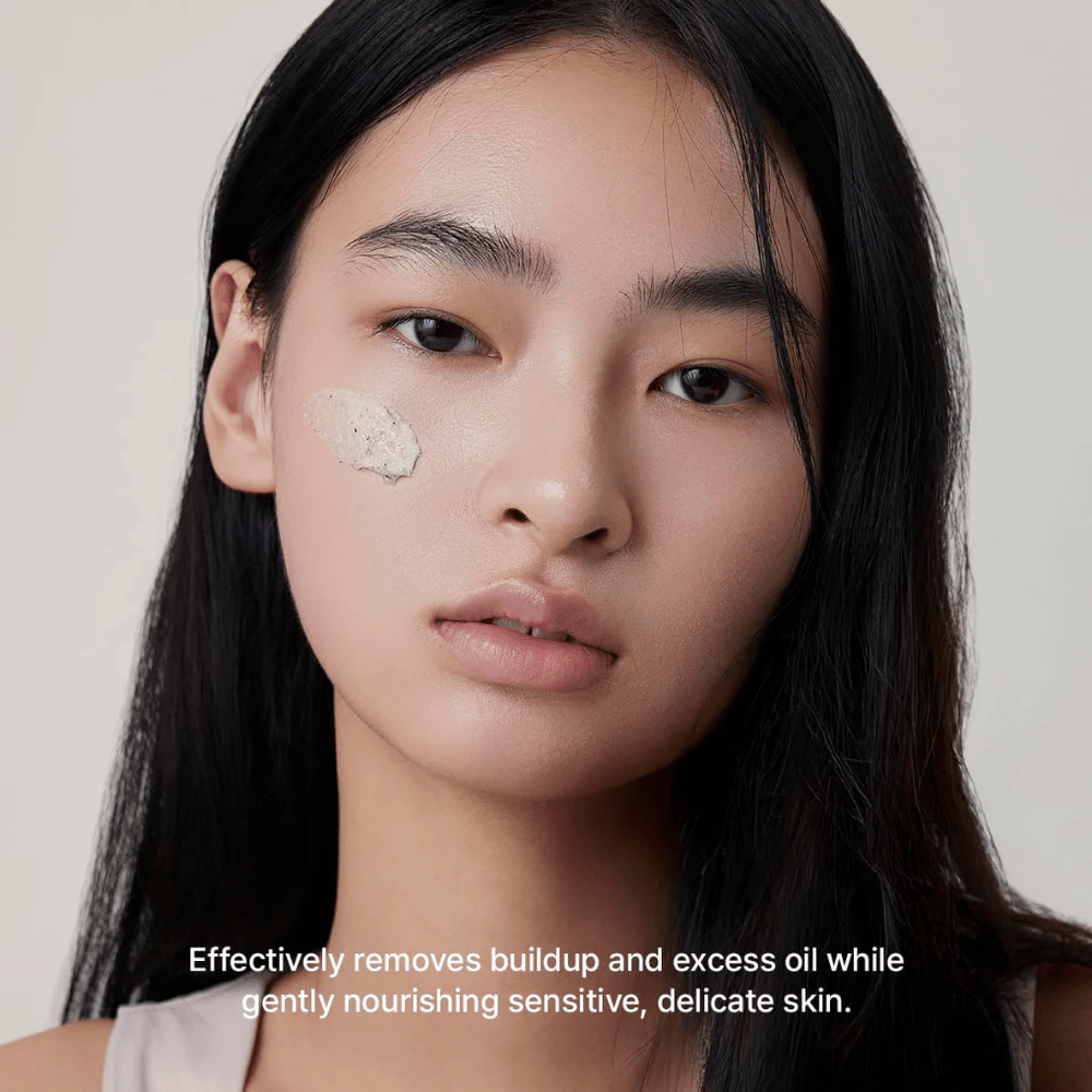 Model z Arencia Rice + LHA Pore Control Rice Cake Cleanser naneseno na lice, blago čistilo za obraz, ki učinkovito odstranjuje umazanijo in odvečni sebum, ne da bi izsušilo kožo.