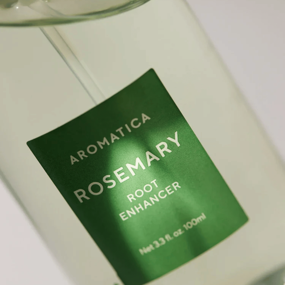 Detajlni posnetek etikete na AROMATICA Rosemary Root Enhancer. Zelena etiketa in prozorna steklenička poudarjata čist in minimalističen videz izdelka.