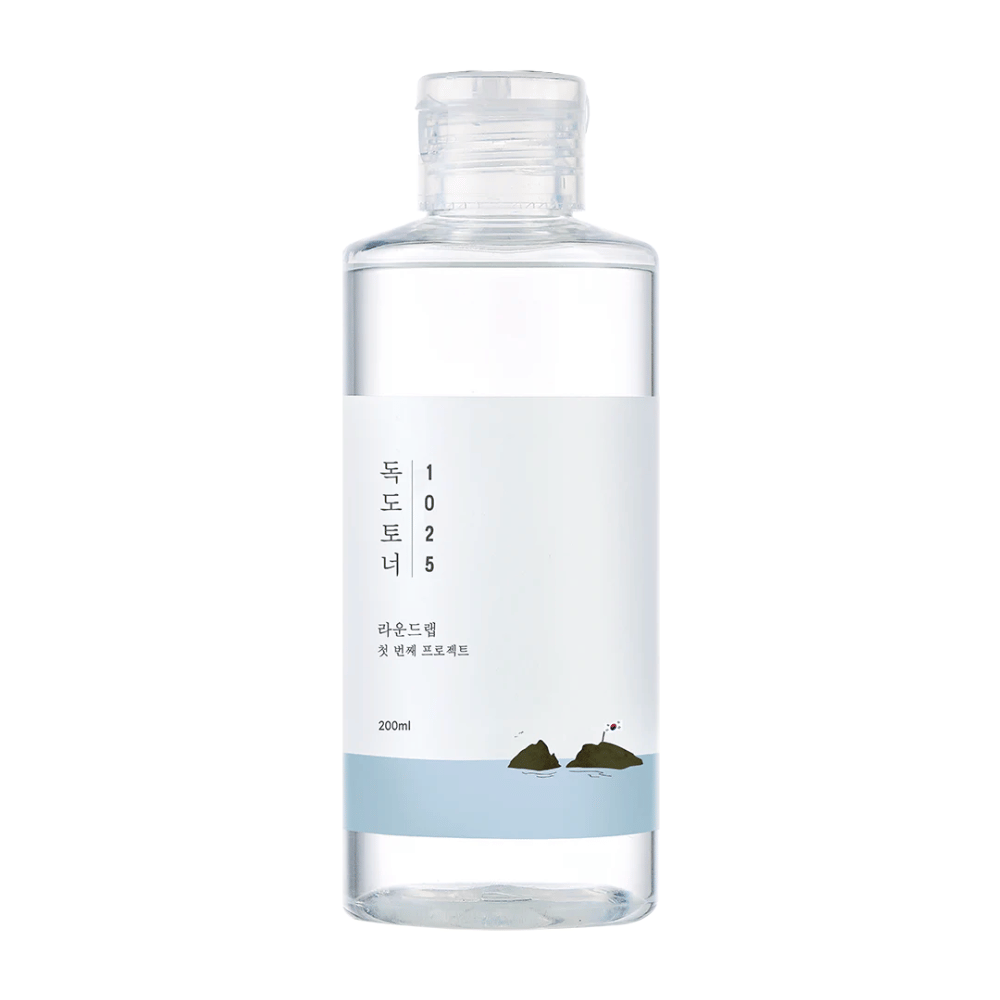 Odprta steklenica Round Lab 1025 Dokdo Toner z enostavnim dizajnom in morsko temo, na beli podlagi.