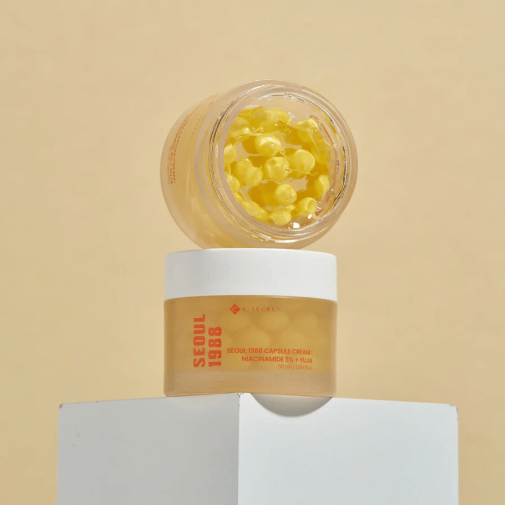 Eleganten prikaz: Dve posodi s Seoul 1988 Capsule Cream, ena odprta in ena zaprta, postavljeni na bež ozadju.