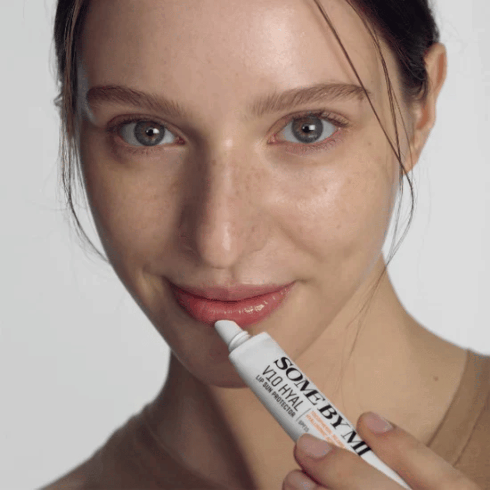Ženska drži tubo V10 Hyal Lip Sun Protector SPF15 7ml balzama za ustnice za zaščito pred soncem in vlaženje, od SOME BY MI.