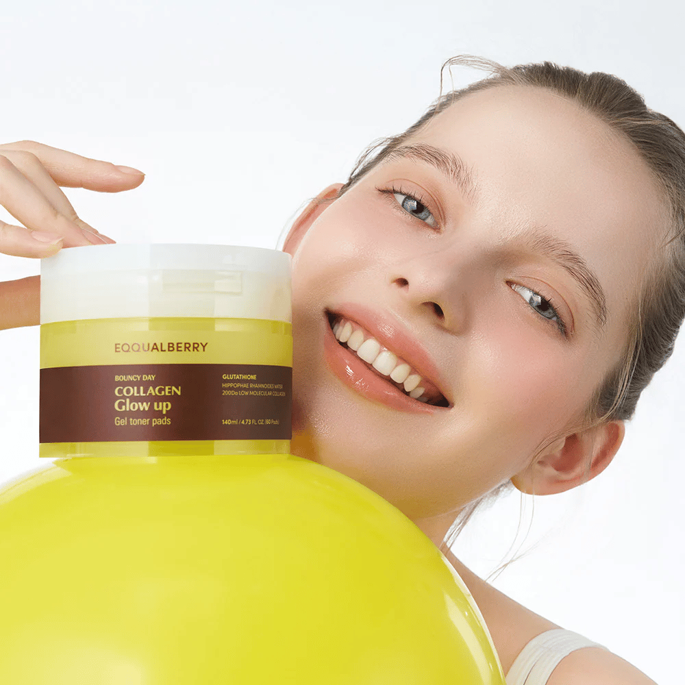 Nasmejana manekenka, ki drži Bouncy Day Collagen Glow up Gel Toner Pads, ki pomagajo zagotoviti mladosten sijaj in čvrstost z nizko molekularnim kolagenom in glutationom.