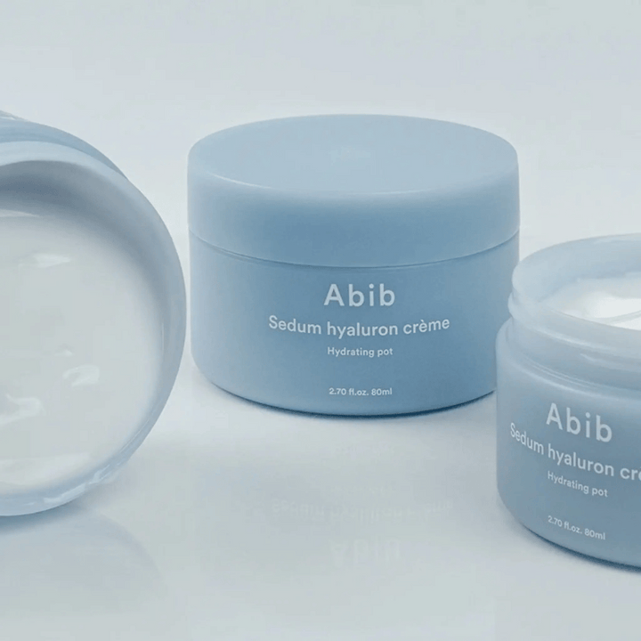 Tri posode Abib Sedum Hyaluron Crème Hydrating Pot 80 ml v svetlo modrem minimalističnem dizajnu, ena odprta posoda prikazuje kremasto belo konsistenco.
