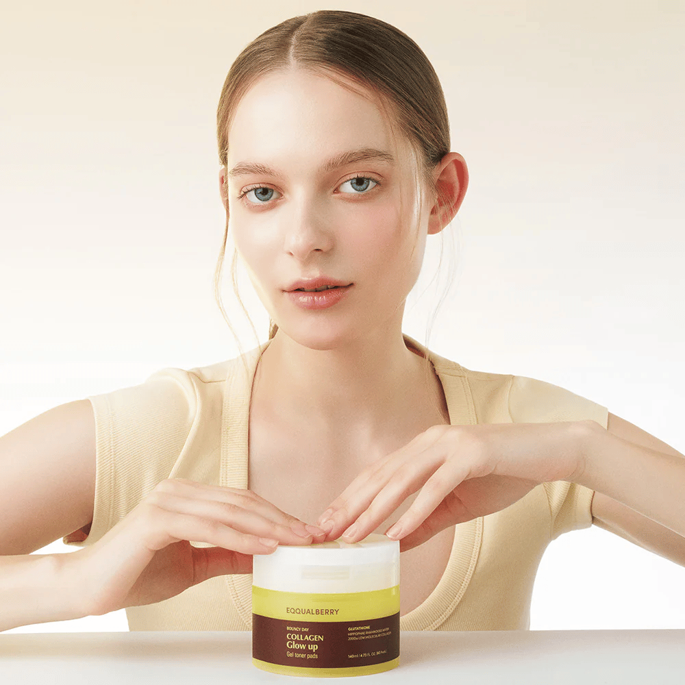 Model, ki drži Bouncy Day Collagen Glow up Gel Toner Pads, ki vlažijo in dajejo čudovit sijaj z nizko molekularnim kolagenom in glutationom.