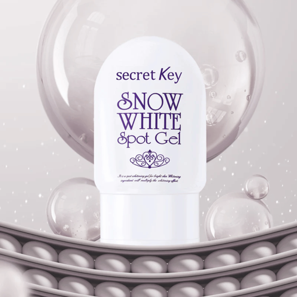 Secret Key Snow White Spot Gel v beli embalaži na ozadju z mehurčki in bisernimi detajli.