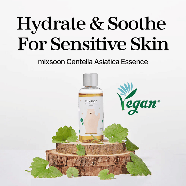 Mixsoon Centella Asiatica Essence z veganskim oznako, steklenica postavljena na leseno ploščo z zelenimi listi, besedilo ”Hydrate & Soothe For Sensitive Skin”.